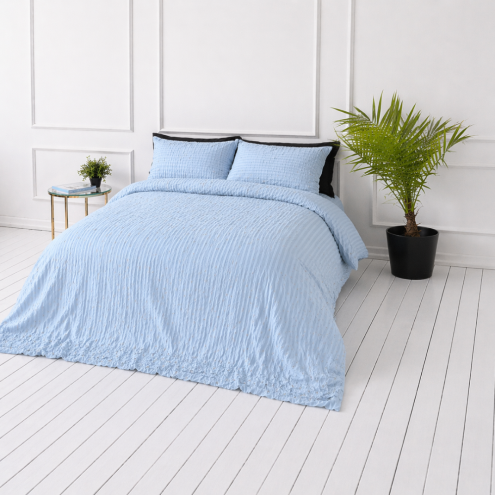 Pussilakanasetti „Kora Dusty Blue“. Yksivärinen pussilakana, 140x200 cm, 150x210 cm, 160x200 cm, 180x200 cm, 200x200 cm, 200x220 cm, 230x220 cm. Pastellinsininen vuodevaatesetti hienovaraisella tekstuurilla.