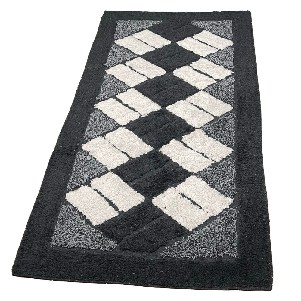 Matto „Black Diamond Mosaic Rug“, 70x140 cm. Musta matto, jossa on kermaisia suorakaiteita dynaamisissa vinoviivoissa. Matto „Black Diamond Mosaic Rug“, 70x140 cm. Musta matto, jossa on kermaisia suorakaiteita dynaamisissa vinoviivoissa.