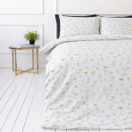 Pussilakanasetti „Enigma“. Kuvioitu pussilakanasetti, 100x140 cm, 140x200 cm, 150x210 cm, 160x200 cm, 180x200 cm, 200x200 cm, 200x220 cm, 230x220 cm. Elegantti valkoinen vuodevaatesetti valkoisella pohjalla, jossa on hienovaraisia keltaisia päivänkakkaroita ja pehmeitä vihreitä varsia.