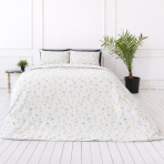 Pussilakanasetti „Enigma“. Kuvioitu pussilakanasetti, 100x140 cm, 140x200 cm, 150x210 cm, 160x200 cm, 180x200 cm, 200x200 cm, 200x220 cm, 230x220 cm. Pehmeä valkoinen vuodevaatesetti romanttisella pienimuotoisella kuviolla keltaisista kukista ja vihreistä kasveista.